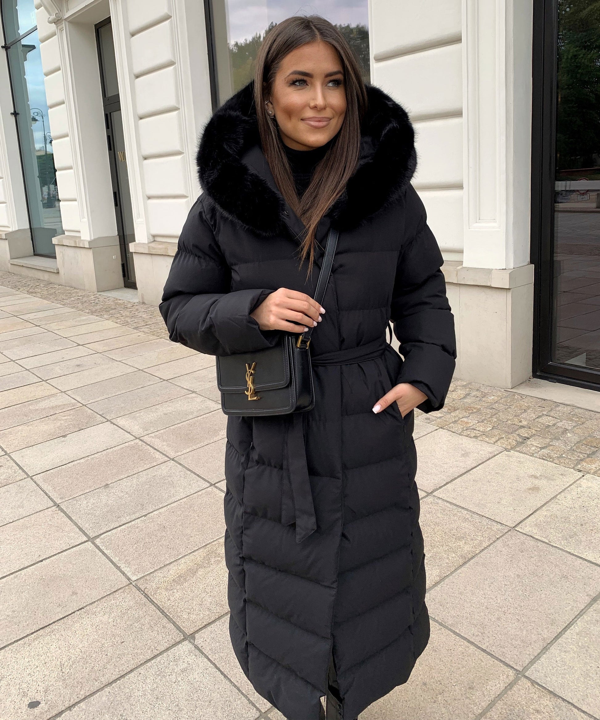 Women's long black puffer coat with a faux fur hood and quilted maxi design