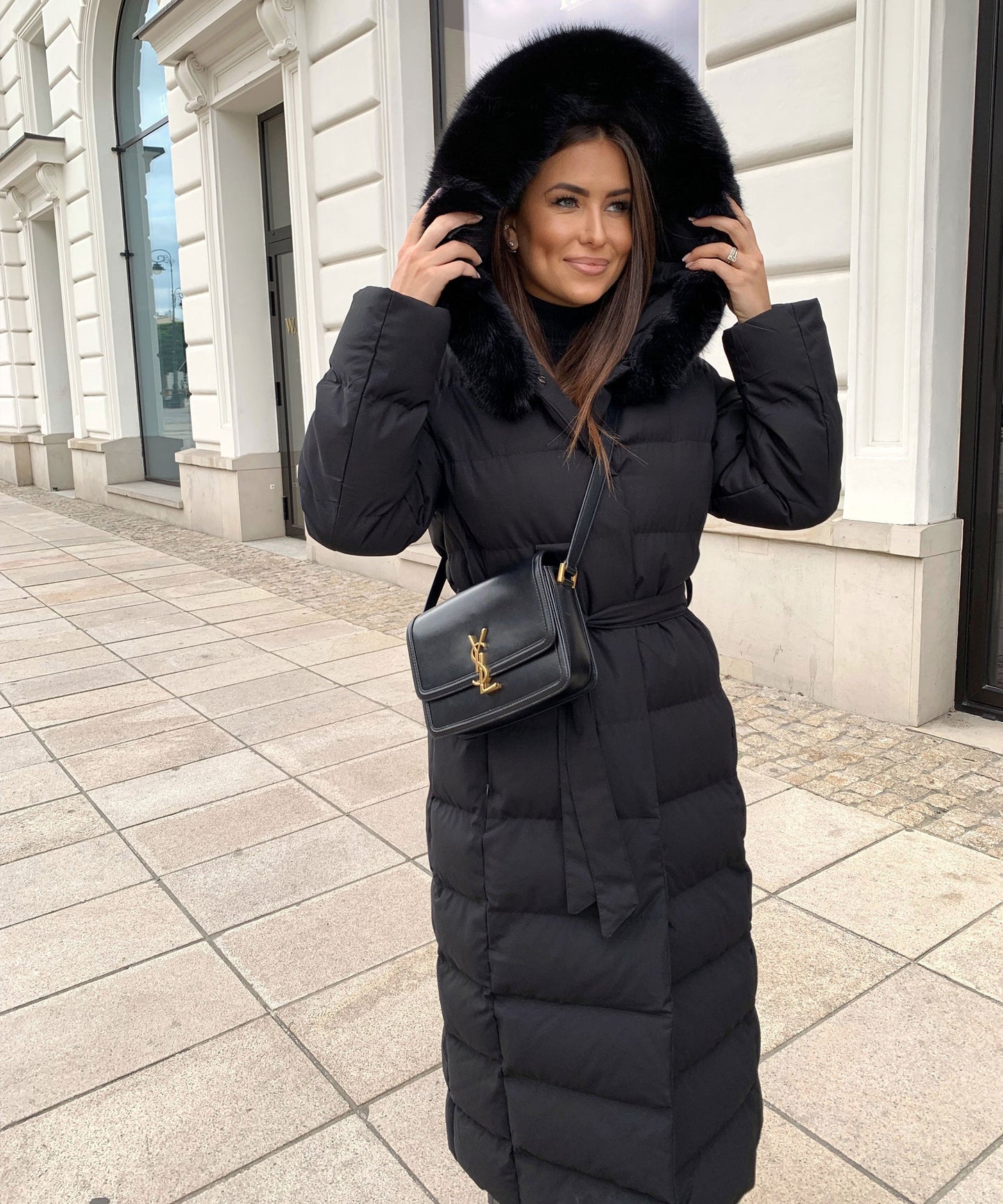 Women's long black puffer coat with a faux fur hood and quilted maxi design
