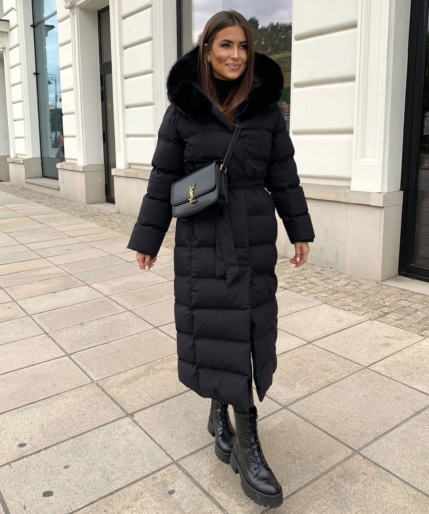 Women's long black puffer coat with a faux fur hood and quilted maxi design