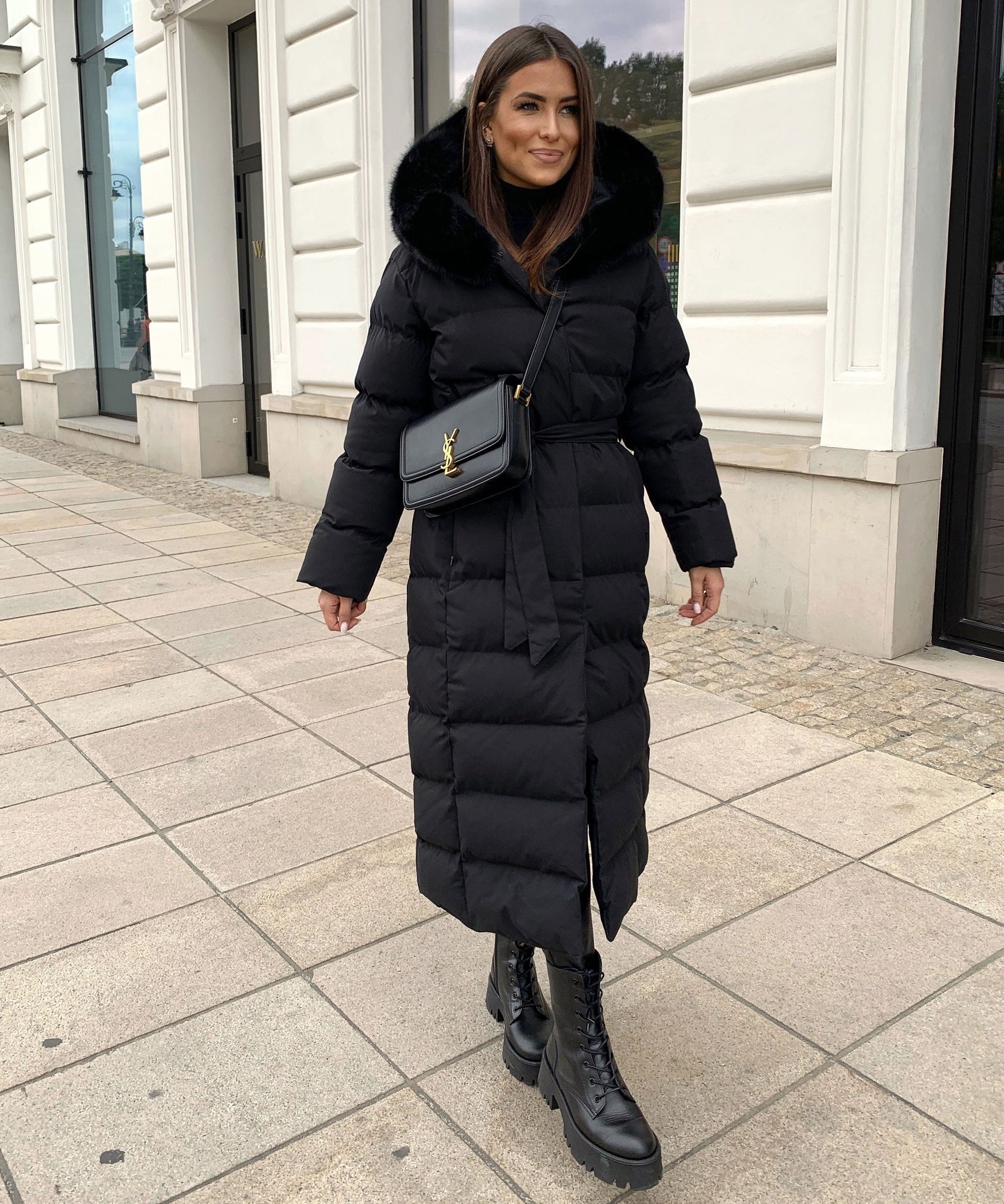 Women's long black puffer coat with a faux fur hood and quilted maxi design