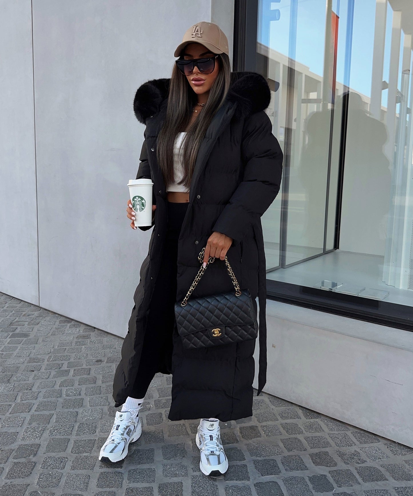 Women's long black puffer coat with a faux fur hood and quilted maxi design