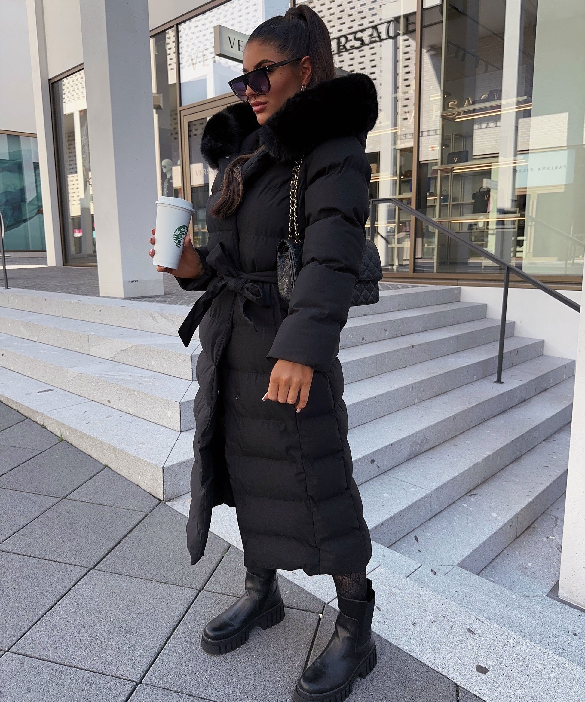 Women's long black puffer coat with a faux fur hood and quilted maxi design