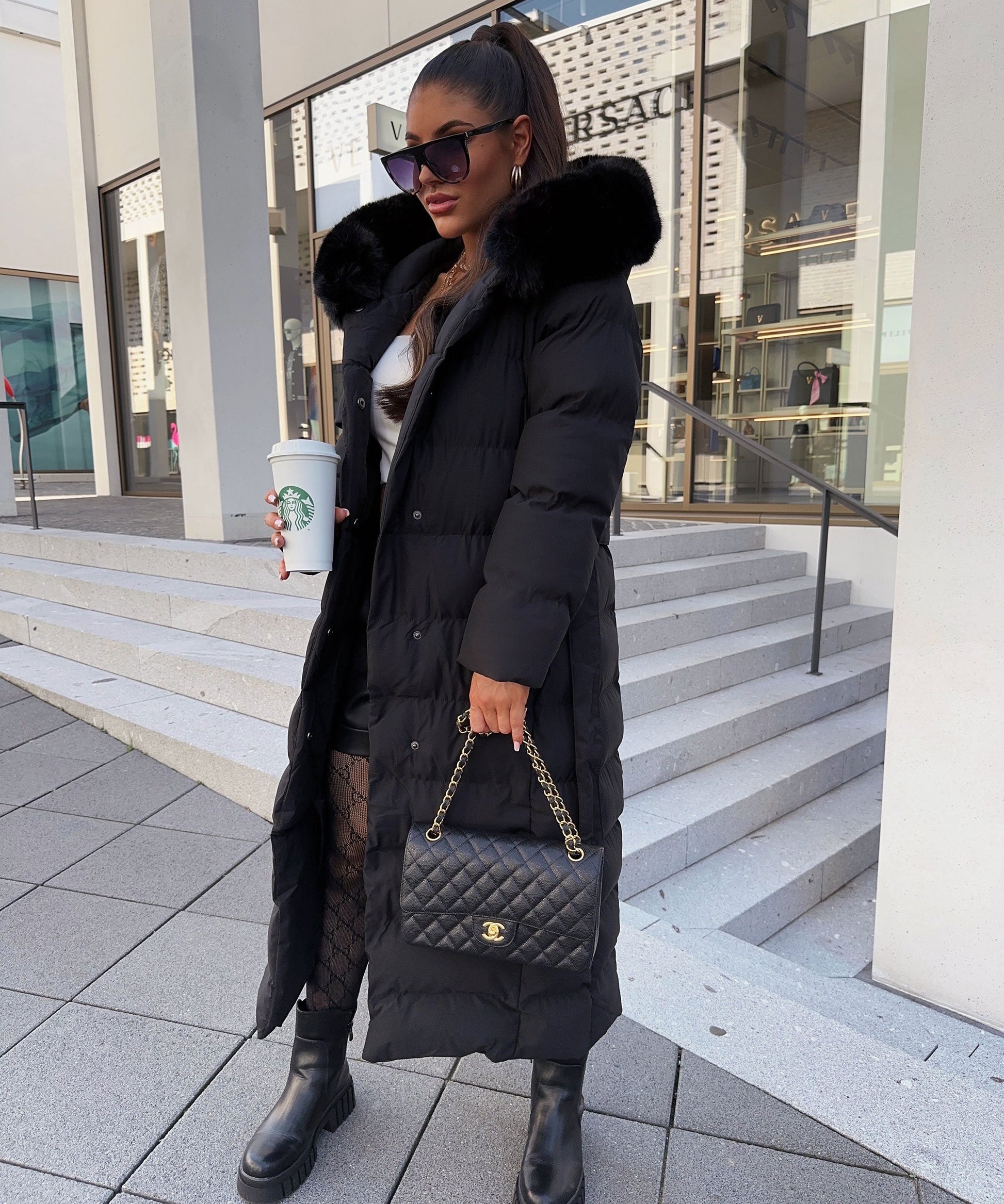 Women's long black puffer coat with a faux fur hood and quilted maxi design