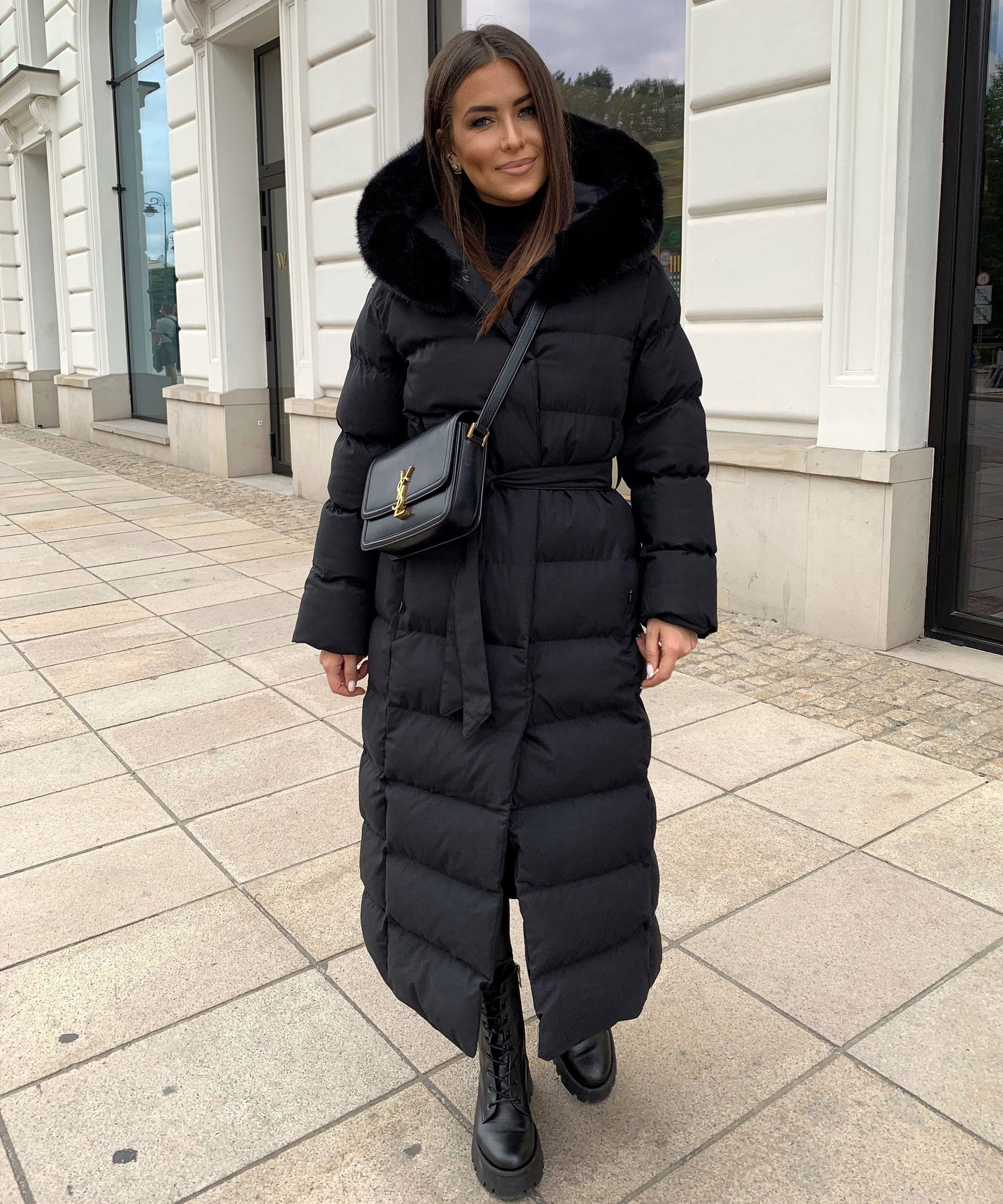 Women's long black puffer coat with a faux fur hood and quilted maxi design
