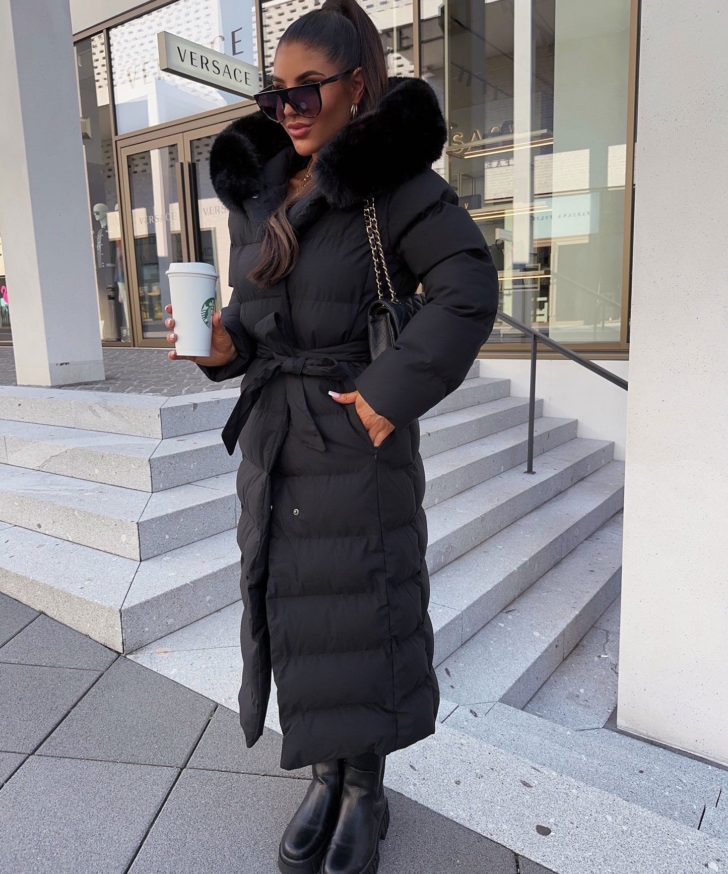 Women's long black puffer coat with a faux fur hood and quilted maxi design