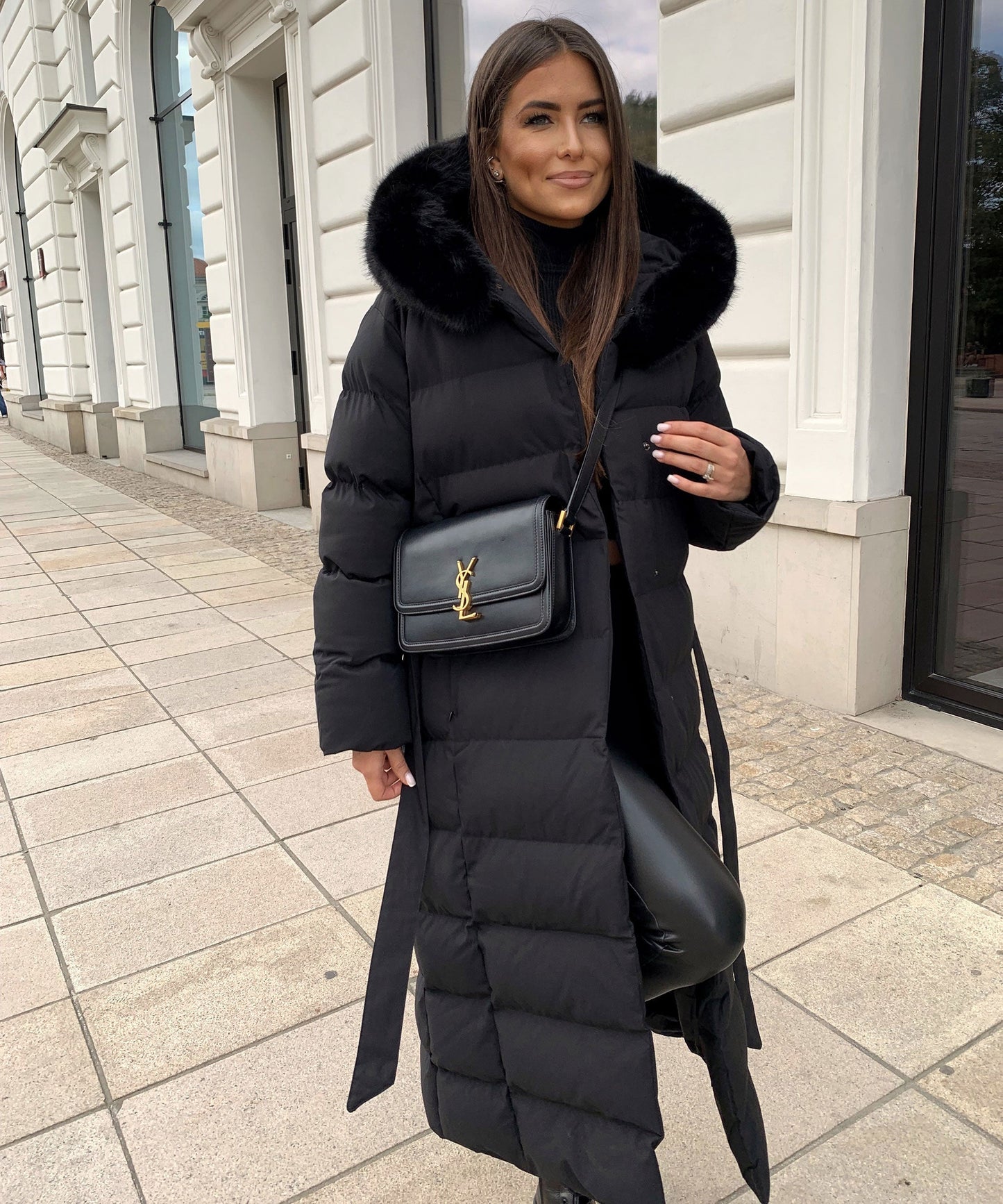 Women's long black puffer coat with a faux fur hood and quilted maxi design